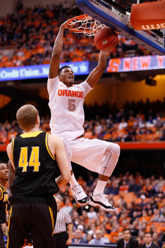 Orange freshman forward Chris McCullough finishes a two-handed dunk as Kennesaw State's Justin Diecker watches.