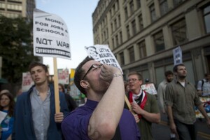 Josh Wilcox, an occupy supporter from Syracuse, screams chants as members of Occupy Syracuse march through city streets on the movement's one year anniversary on Monday evening. Occupy Syracuse is now less visible as members move toward more specific goals.