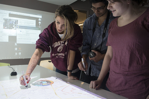 Students gather around an interactive table at the ThinkLab, located on the fourth floor of the Design Warehouse. ThinkLab has been lending their space out to Studio C, an up-and-coming project dedicated to connecting entrepreneurs bettering the civic good of Syracuse. 