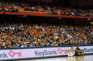 Syracuse guard Brandon Triche sits at the scorer's table before entering as the home crowd for SU's first home game of the season looks on.