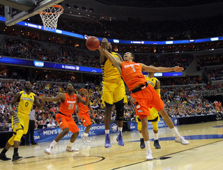 Michael Carter-Williams #1 of the Syracuse Orange puts the ball up to the basket against Chris Otule #42.