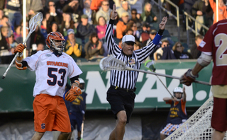 Luke Cometti stands next to the referee as he signals a goal.