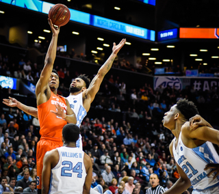 Battle lofts a floater in traffic, one of his signature moves to finish near the rim. Used especially against taller defenders, he lofts the shot off the backboard from the right block area. 