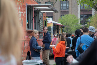 Students stand in line waiting for food from the Toss & Fire pizza truck. Food trucks Limp Lizard BBQ and Baja Cali Taco Co. also parked their trucks at the event.